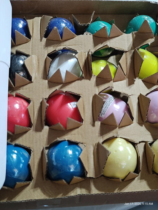 Colorful bouncy balls set in a cardboard box, featuring various vibrant colors and designs.