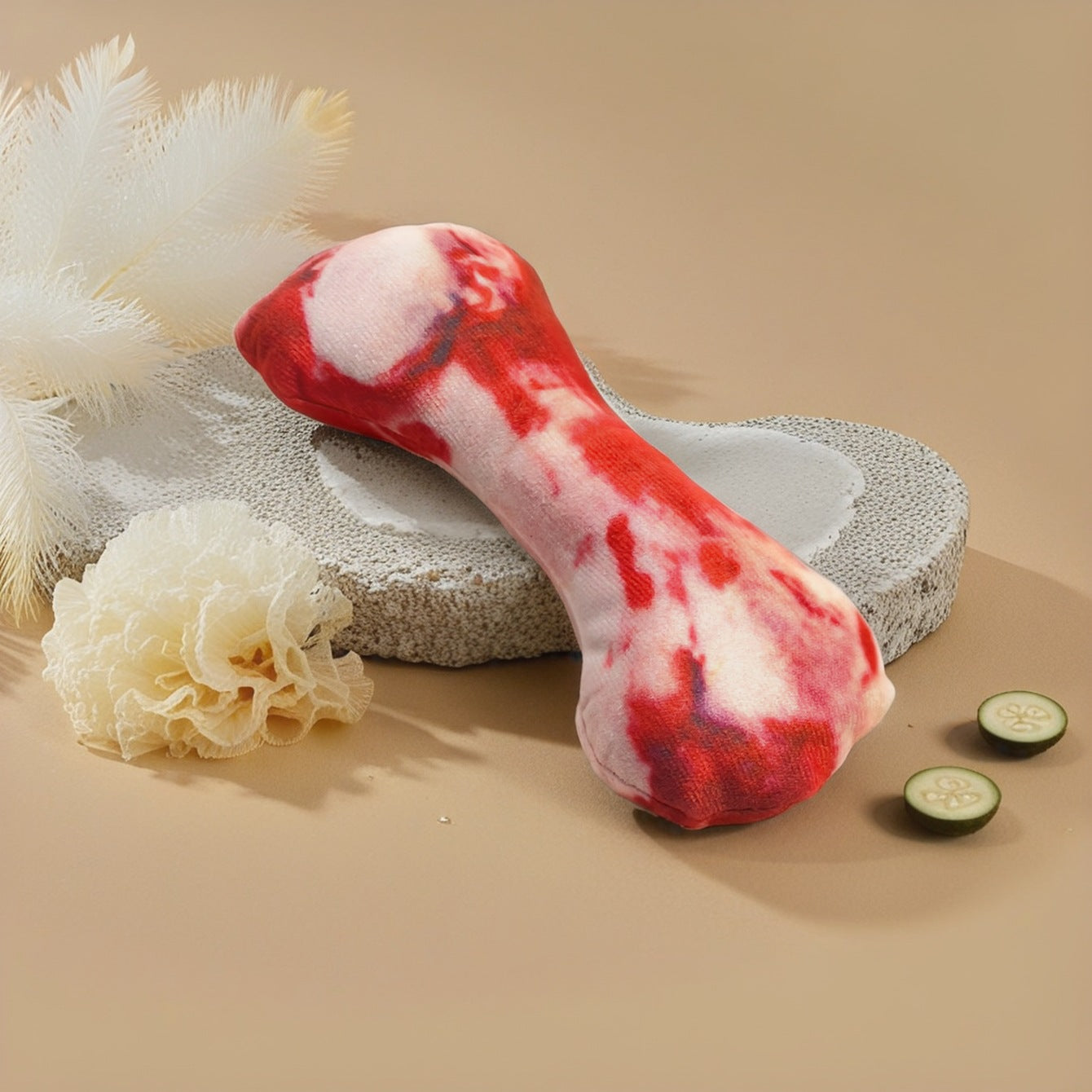 Colorful dog chew toy in red and pink hues, placed on a textured surface.