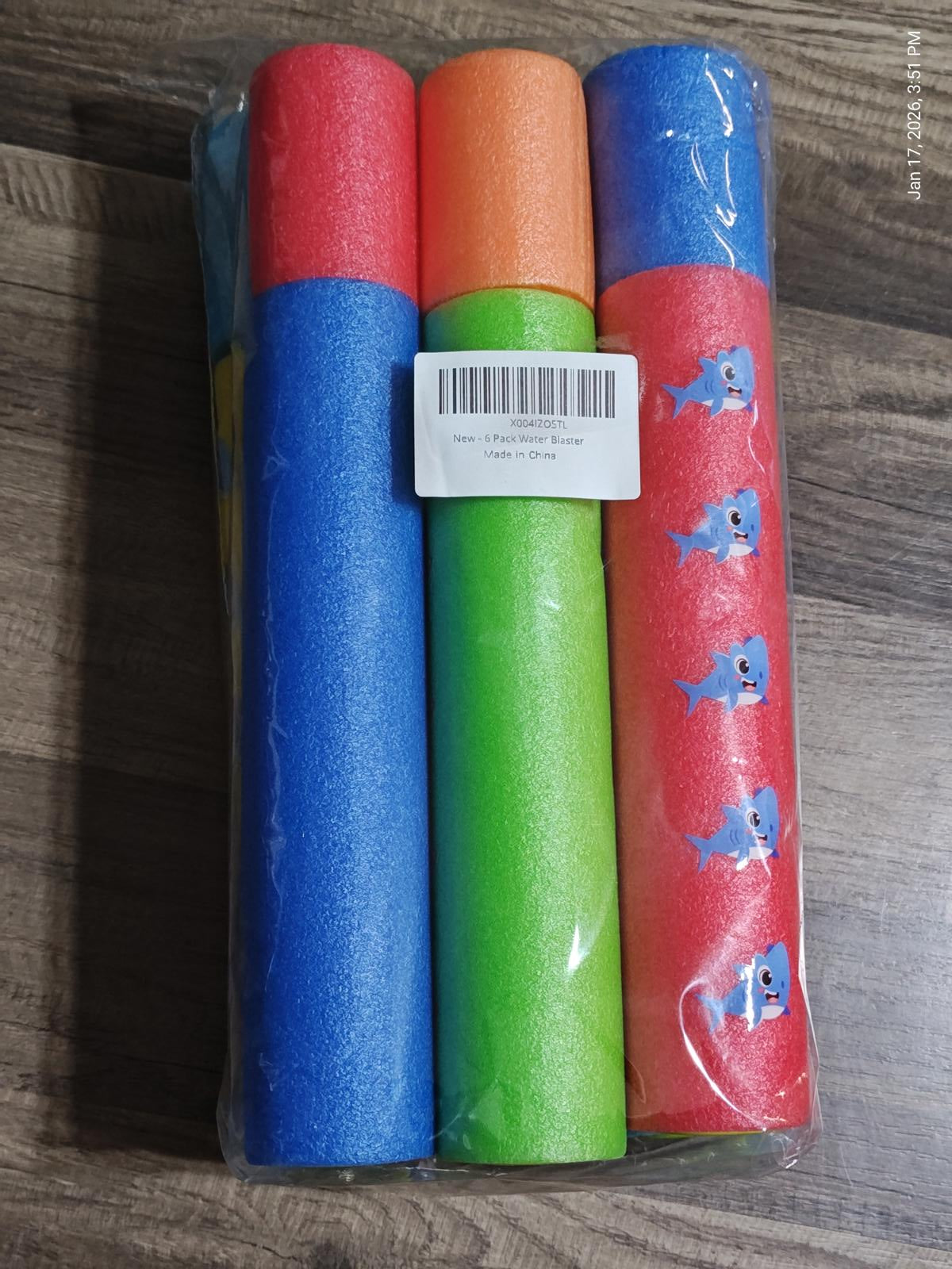 Colorful foam pool noodles in green, blue, and orange, perfect for summer fun.