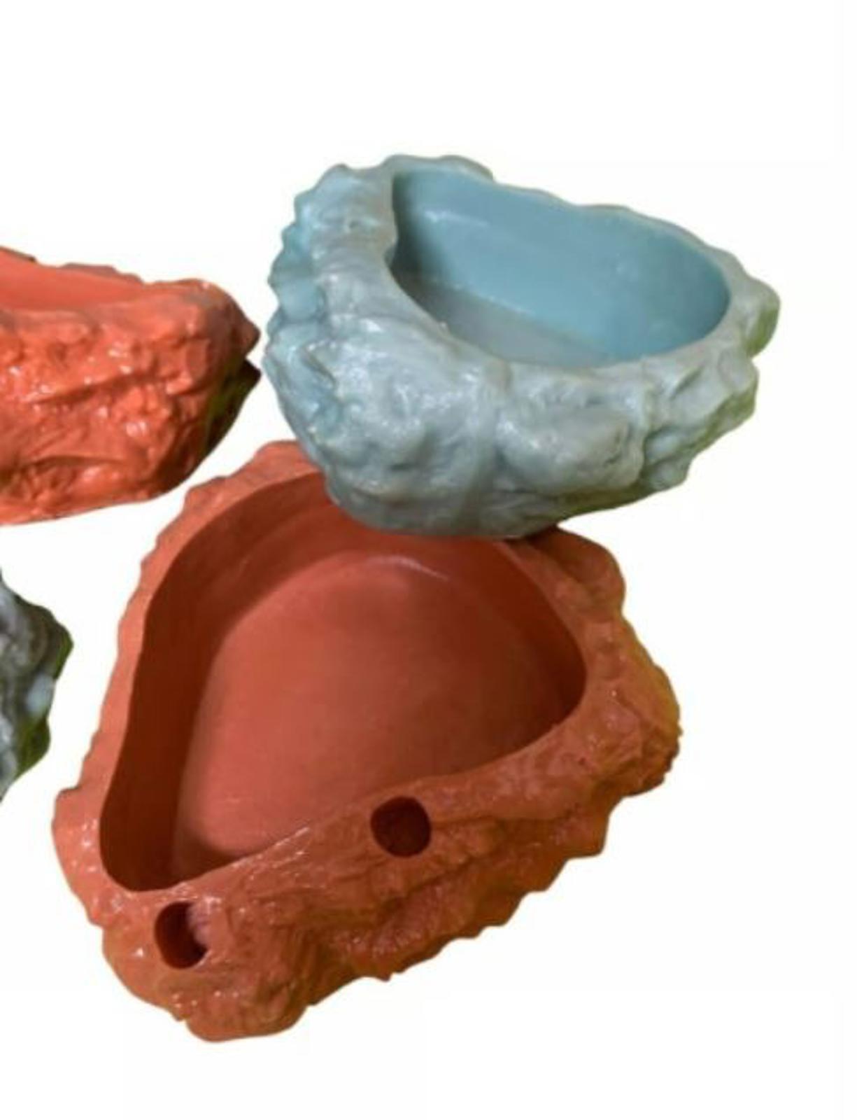 Colorful rock-shaped pet food bowls in coral and blue. Ideal for stylish pet dining.