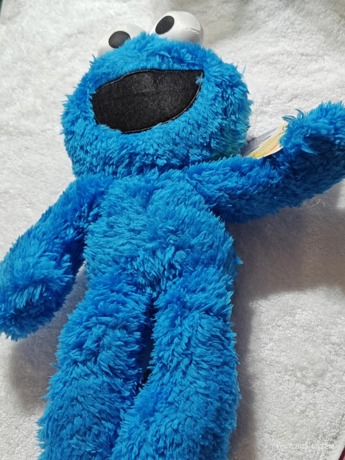 Cookie Monster plush toy in bright blue color with a friendly smile.