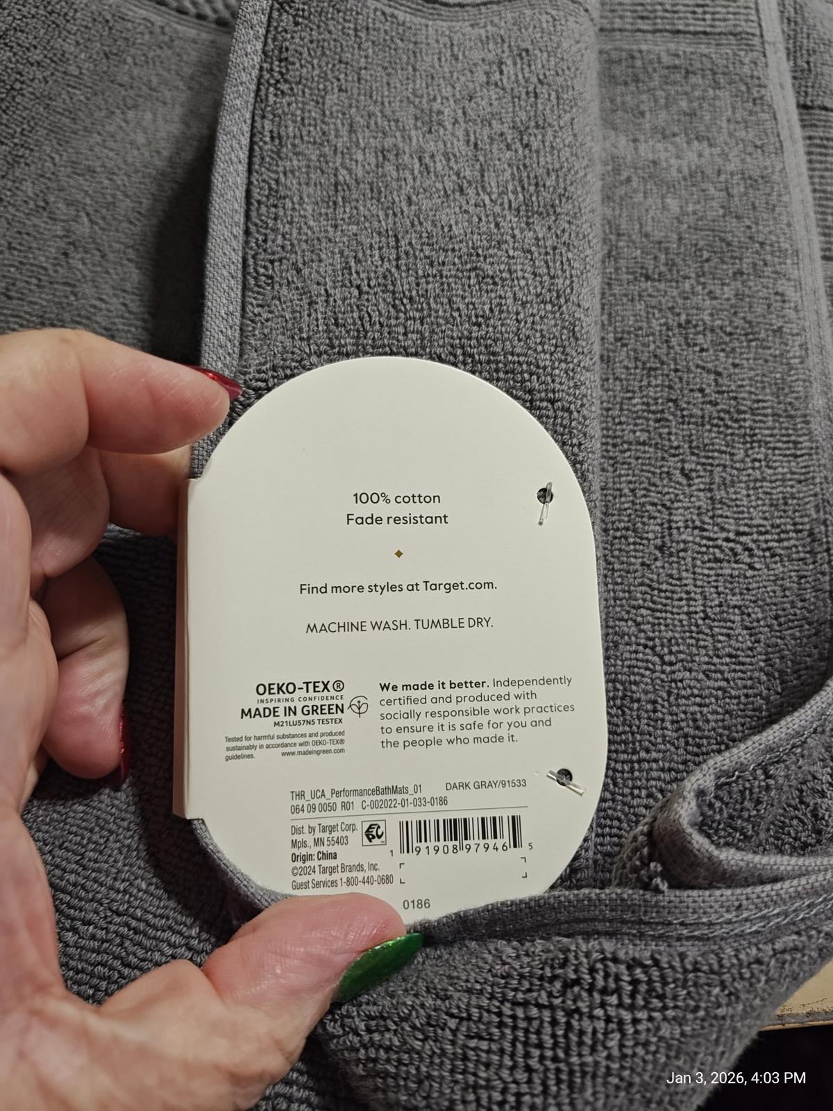 Cotton towel tag showing 100% cotton and fade resistance features.