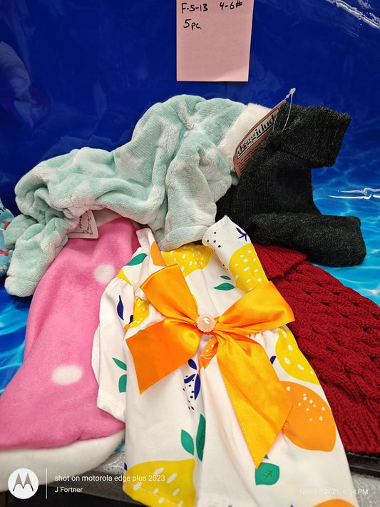 Cozy fleece blanket and colorful accessories including a floral dress with a bow and knitted socks.