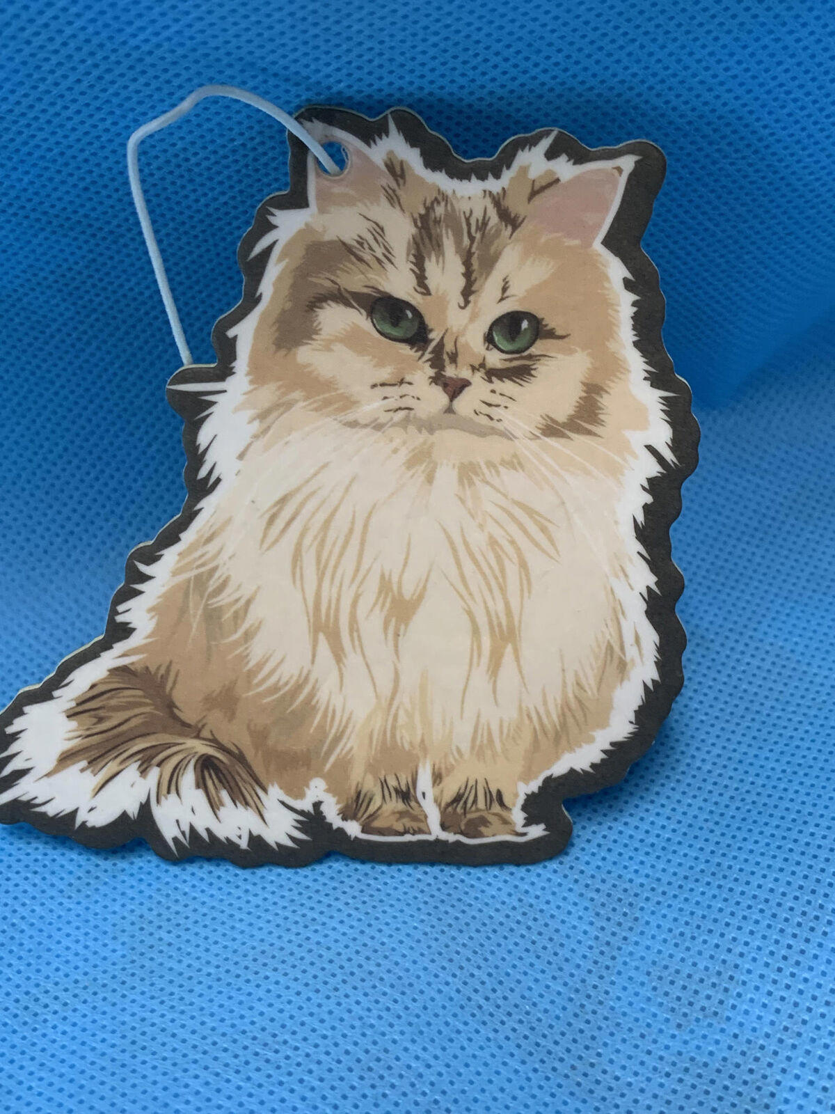 Cat-shaped air freshener featuring a fluffy Persian cat design with green eyes.