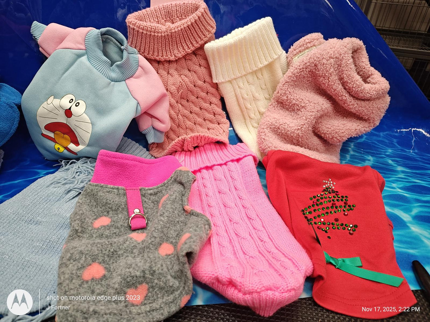 Colorful pet sweaters and socks including pink, gray, and red designs for dogs.