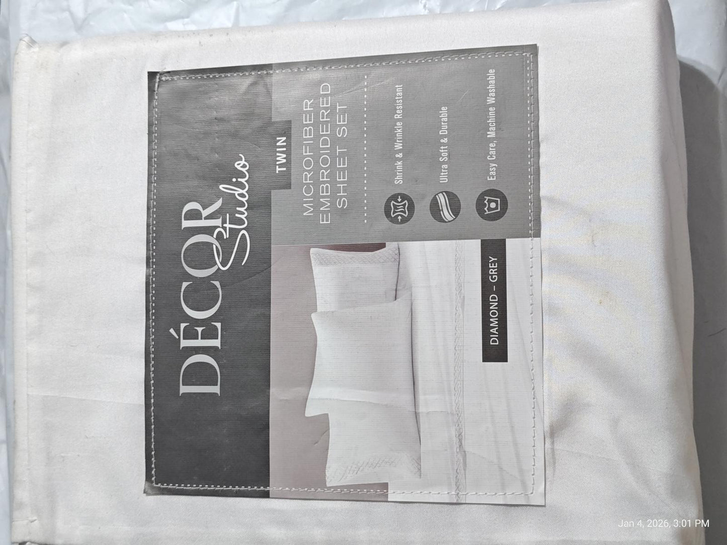 Décor Studio white luxury bed sheet set with embroidered details and packaging.