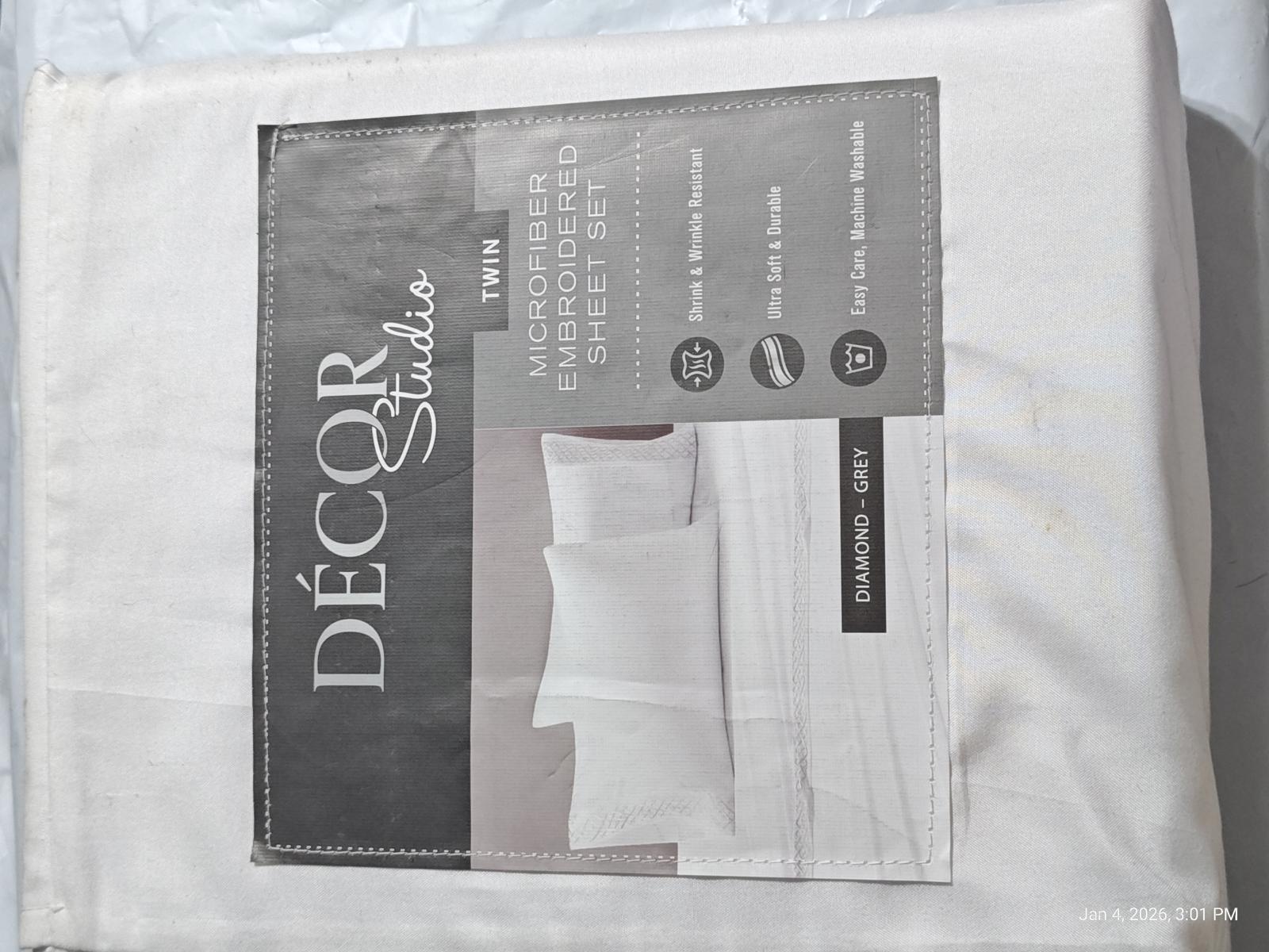 Décor Studio white luxury bed sheet set with embroidered details and packaging.