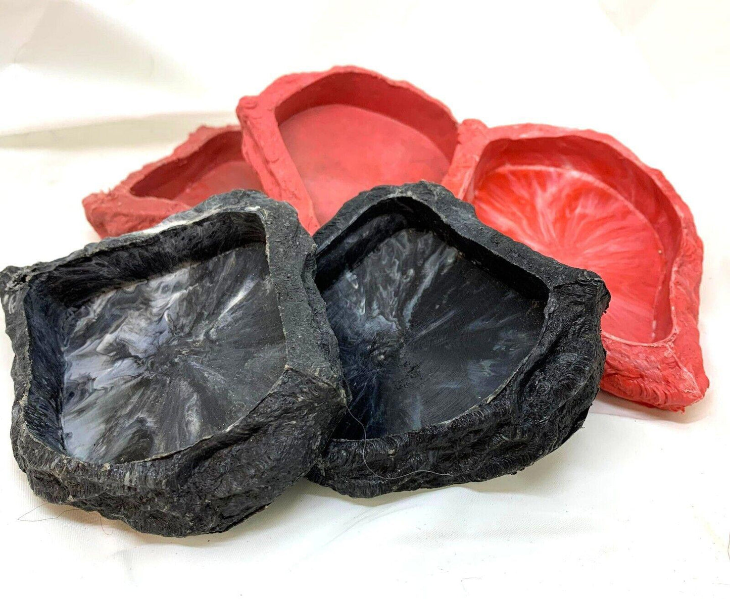 Rock-shaped pet food bowls in black and red colors, perfect for stylish feeding.