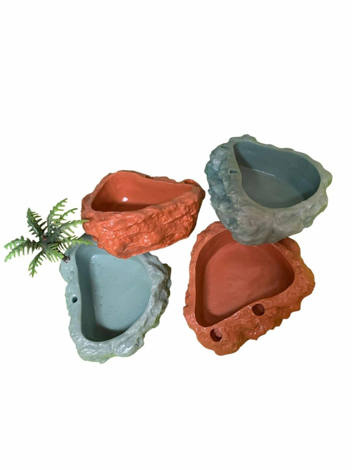 Decorative rock-shaped pet food and water bowls in blue and terracotta colors.