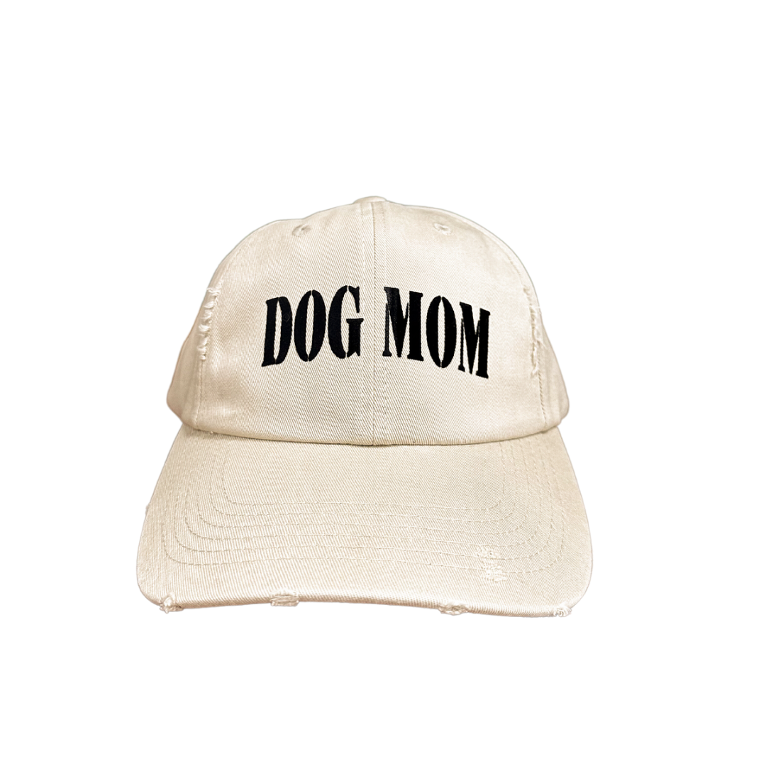 Dog Mom cap featuring a beige color and bold black lettering.