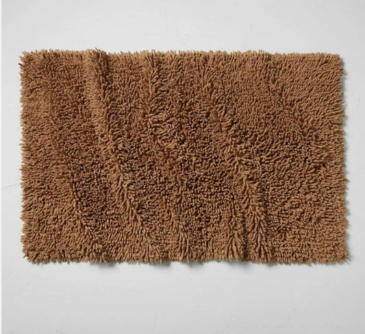 Brown shaggy bath mat with a soft texture, perfect for adding warmth to your bathroom.