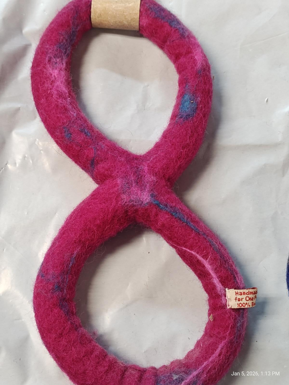 Felted wool cat toy in a pink eight shape, designed for playful cats.