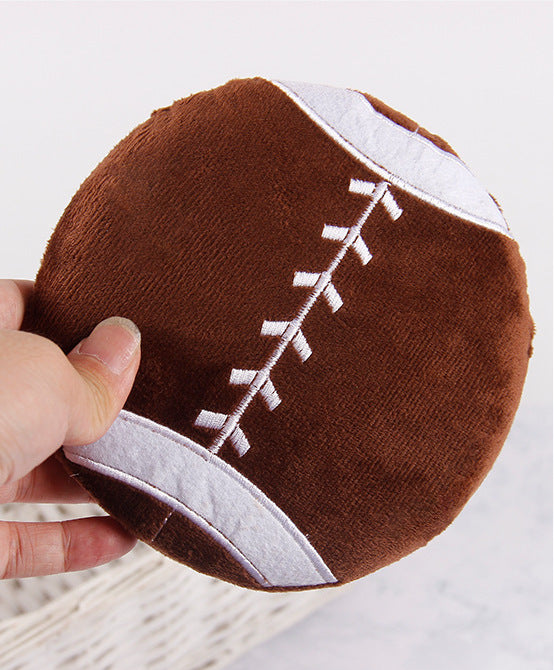 Football plush pillow with detailed stitching and soft texture.