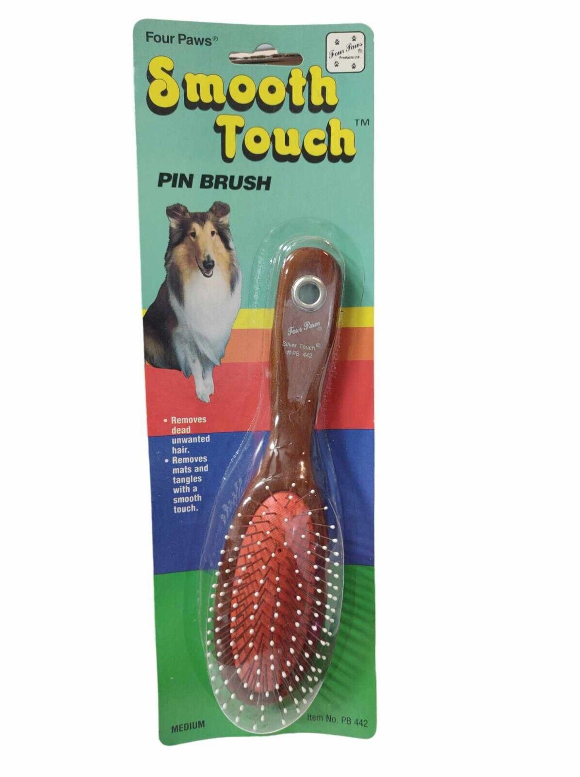 Four Paws Smooth Touch pin brush with a wooden handle and red bristles for grooming pets.