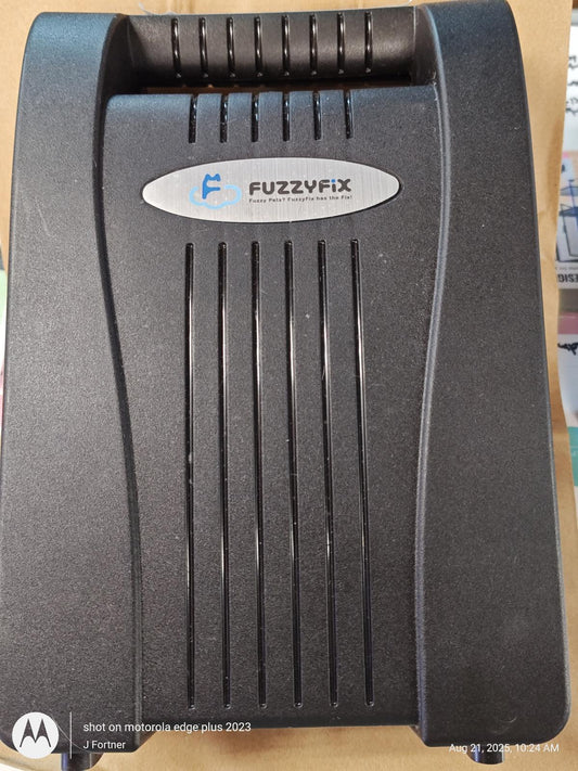 FuzzyFix device with a sleek black design and a silver logo on the front.