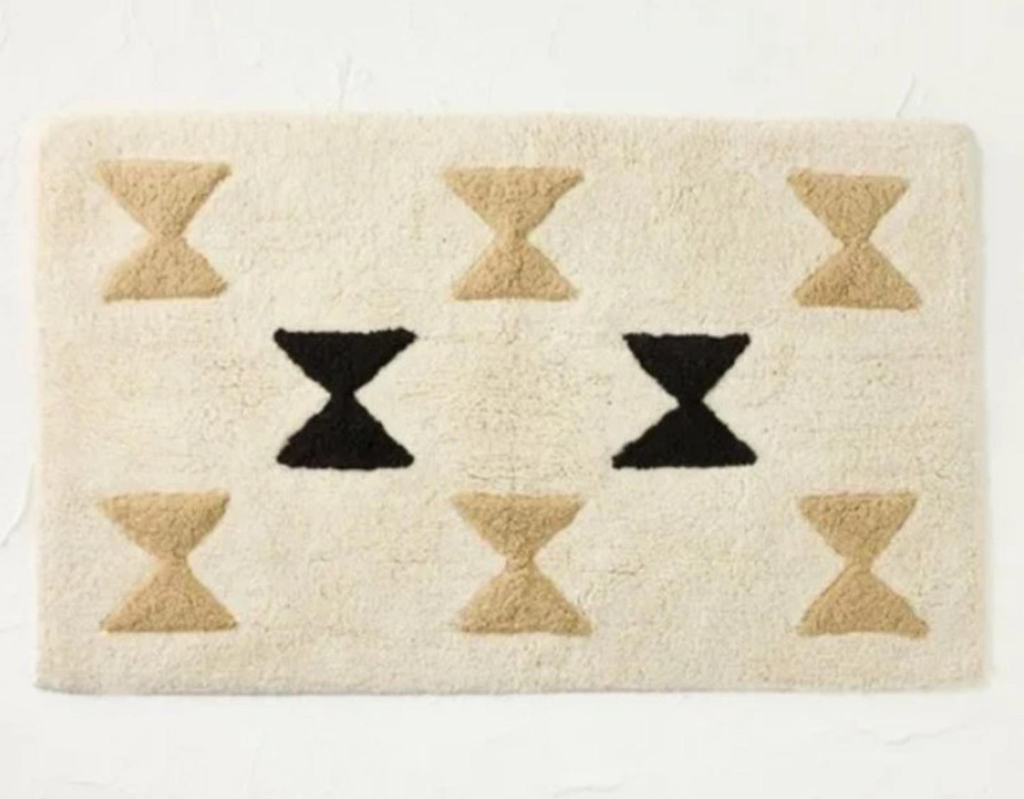 Geometric Cream Area Rug featuring black and beige hourglass patterns.