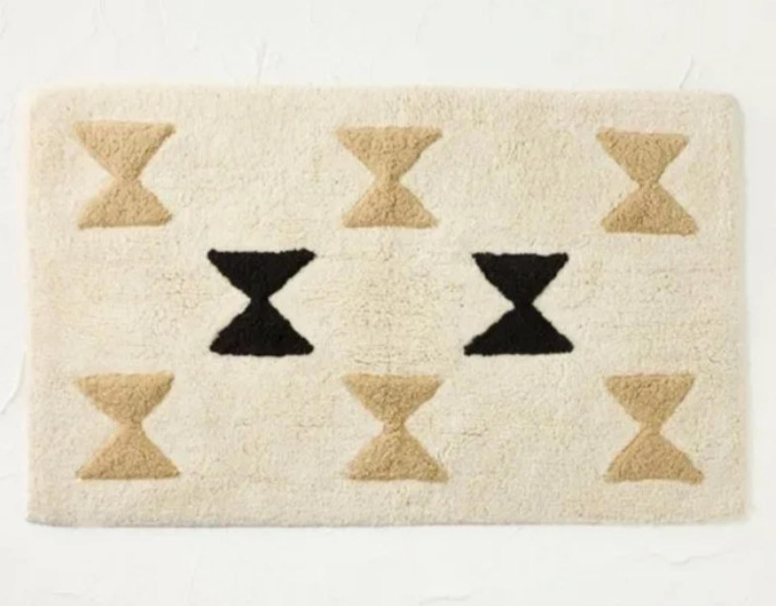 Geometric Cream Area Rug featuring black and beige hourglass patterns.