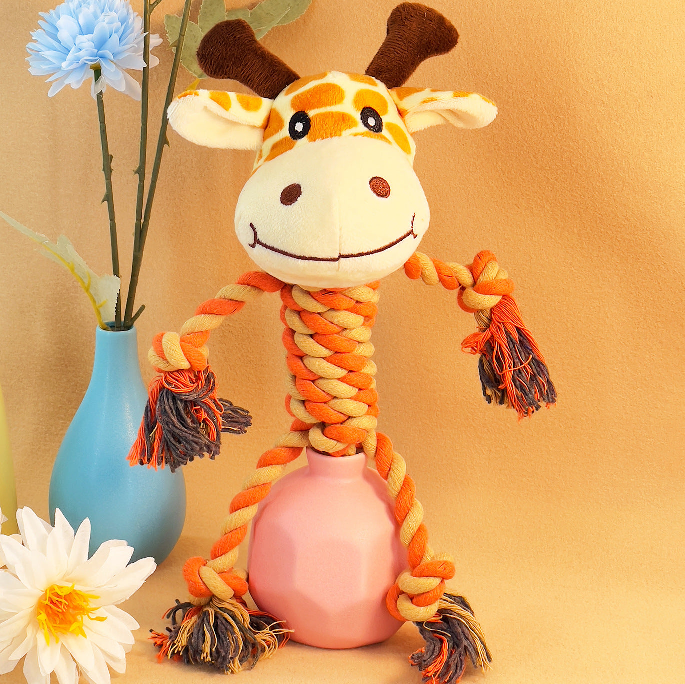 Giraffe plush toy with rope limbs and a pink base, perfect for playful pets.