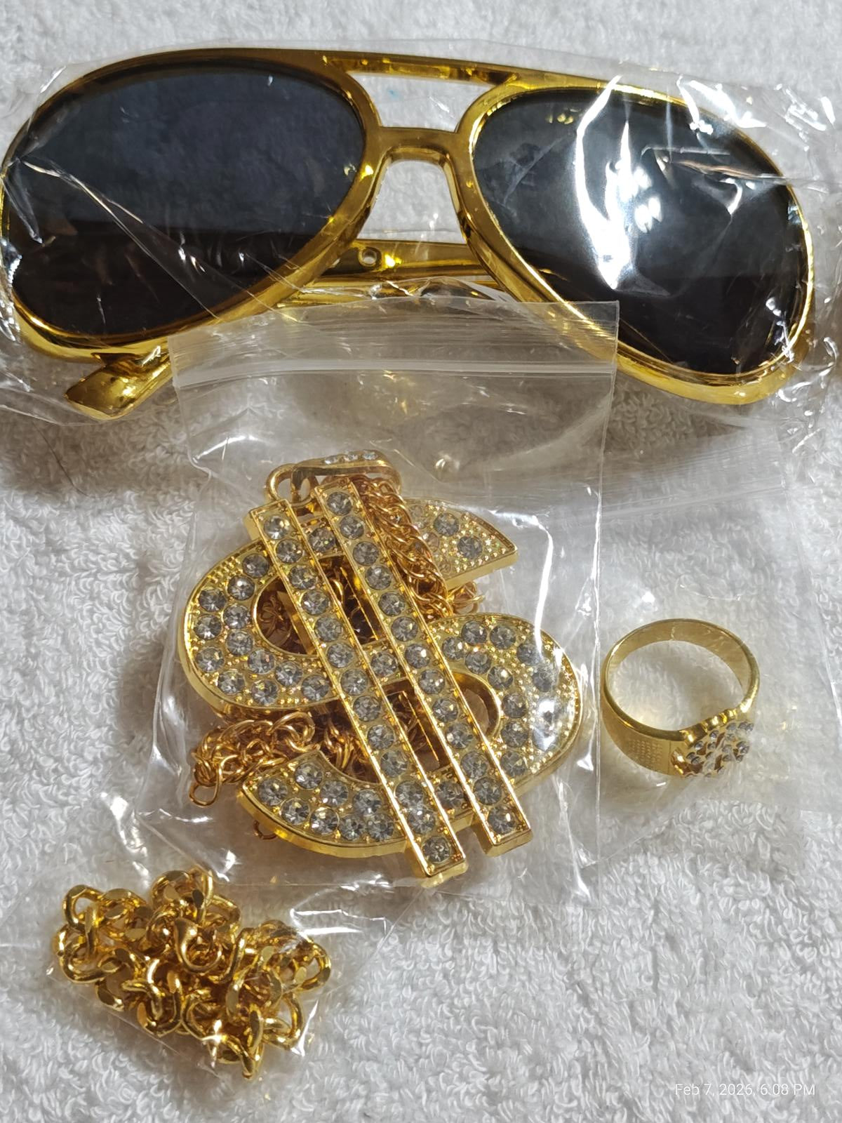 Gold sunglasses with a sparkling dollar sign necklace and ring set, perfect for stylish accessories.