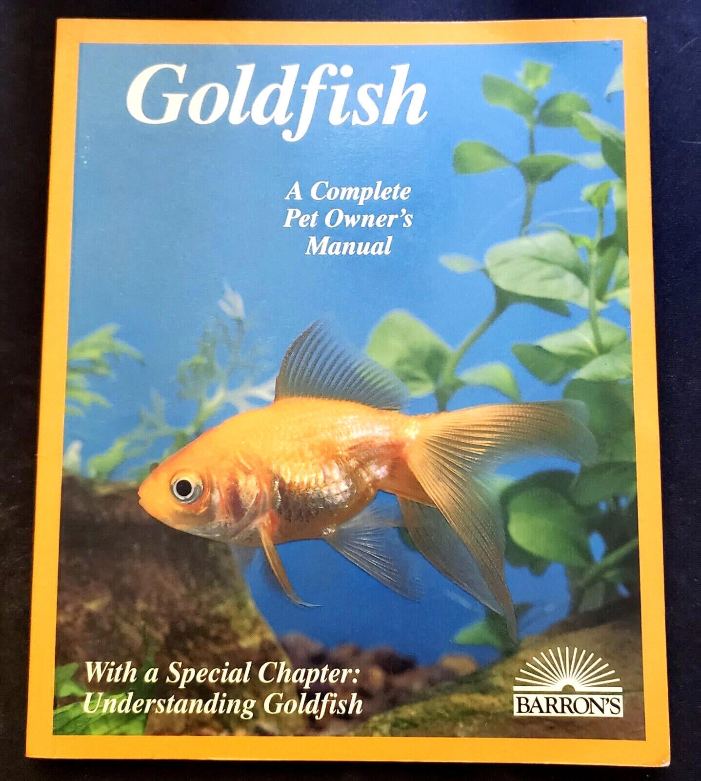 Goldfish pet owner's manual featuring a goldfish swimming among aquatic plants.