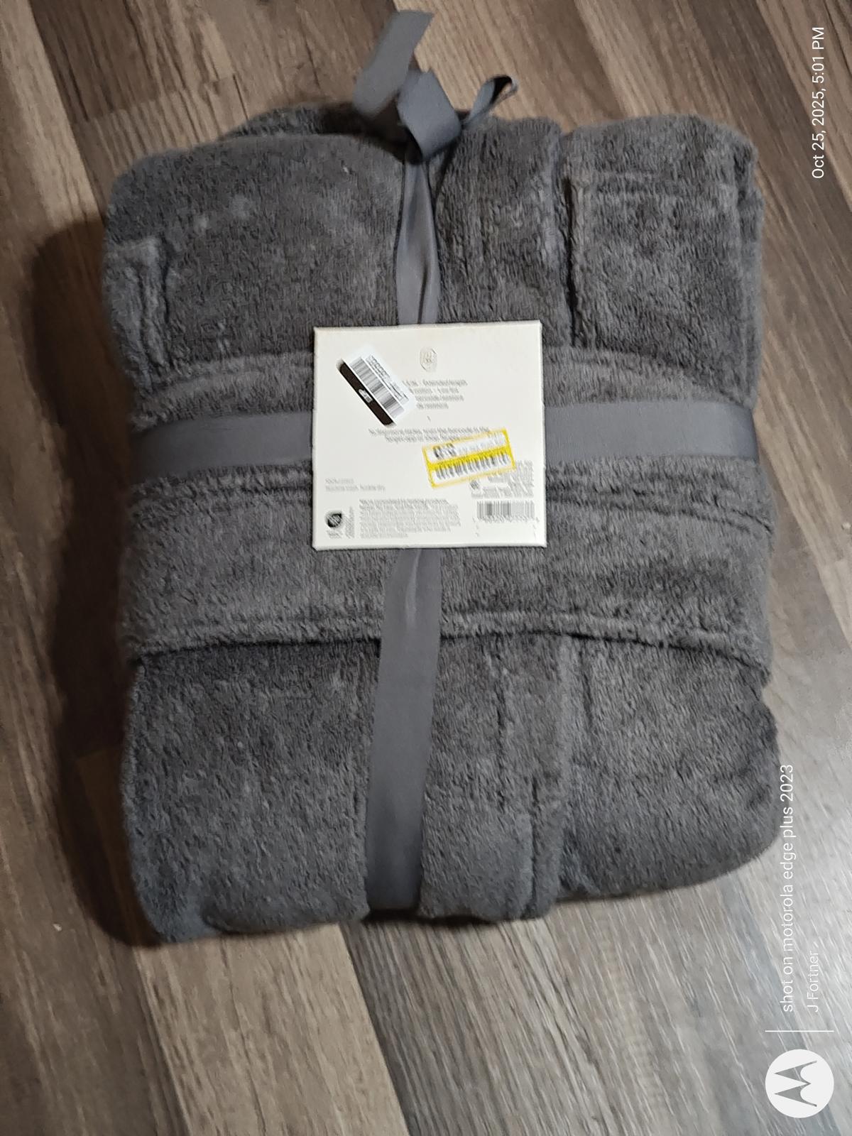 Gray plush bath towel set with a ribbon and tag, featuring soft texture and absorbent material.