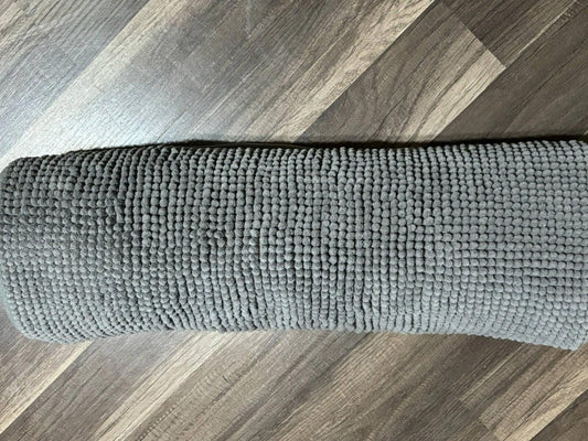 Gray waffle weave bath mat with a soft texture for comfort.