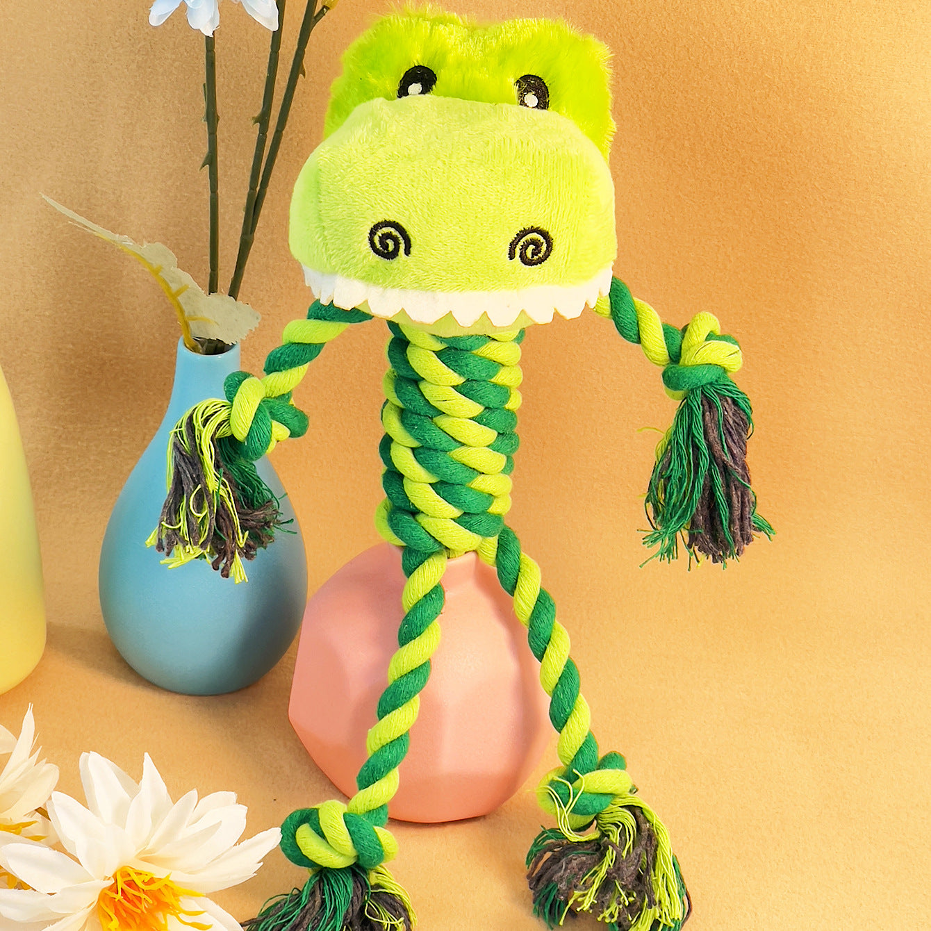 Green Dinosaur Rope Toy with plush head and braided body for dogs.