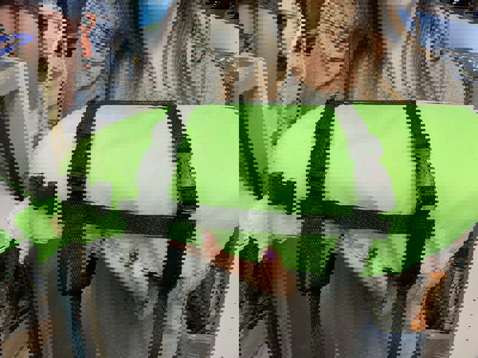 Green flotation device with black straps, ideal for water safety.