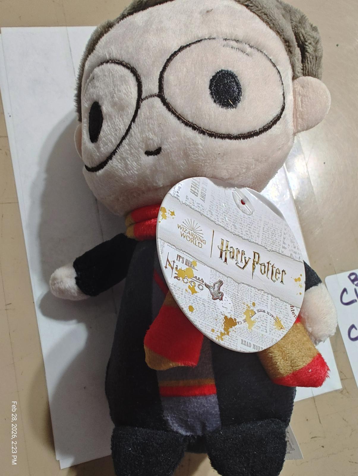 Harry Potter plush toy with glasses and a scarf, featuring a tag.
