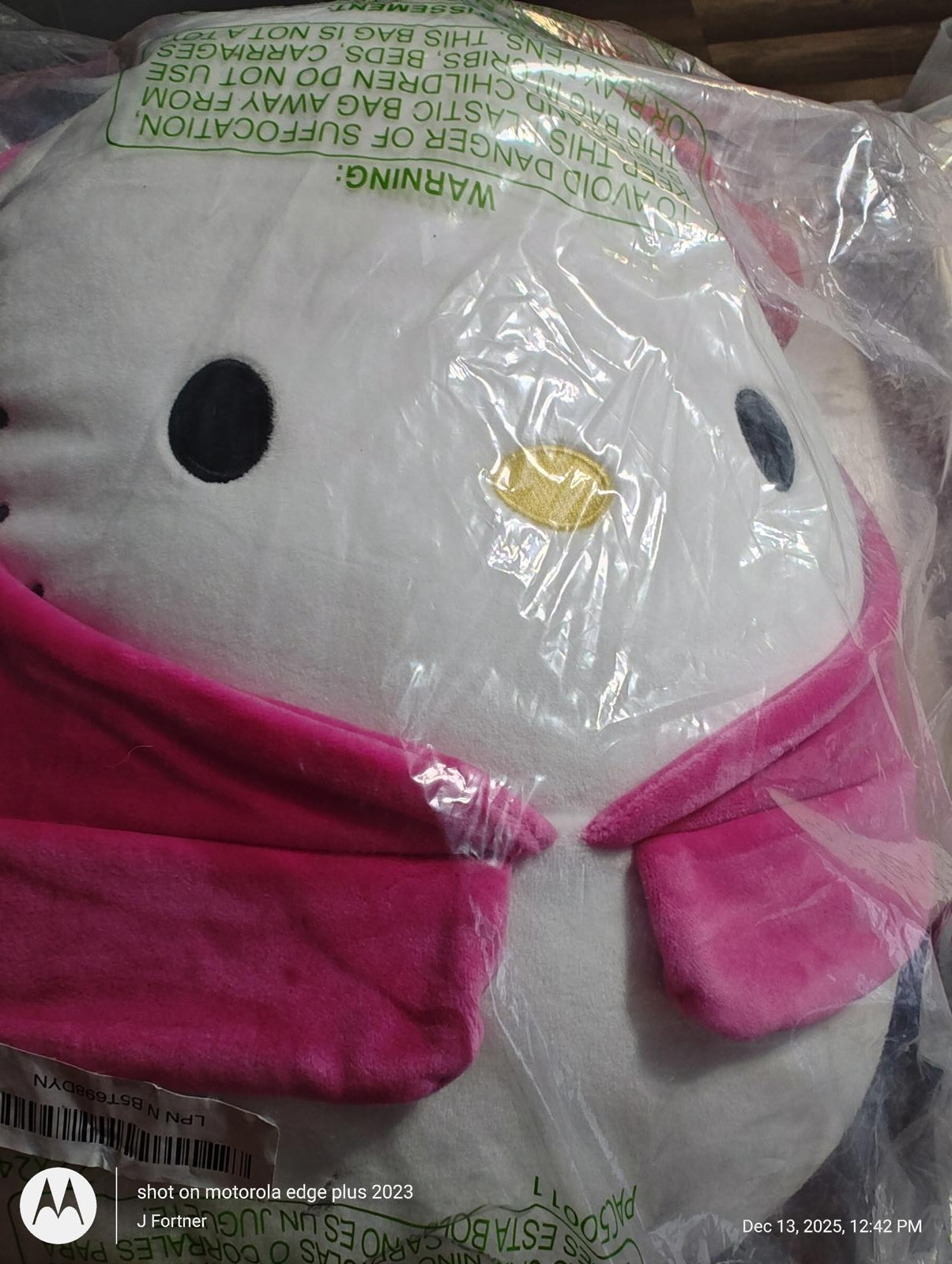 Hello Kitty plush toy with pink accents and a cheerful expression.