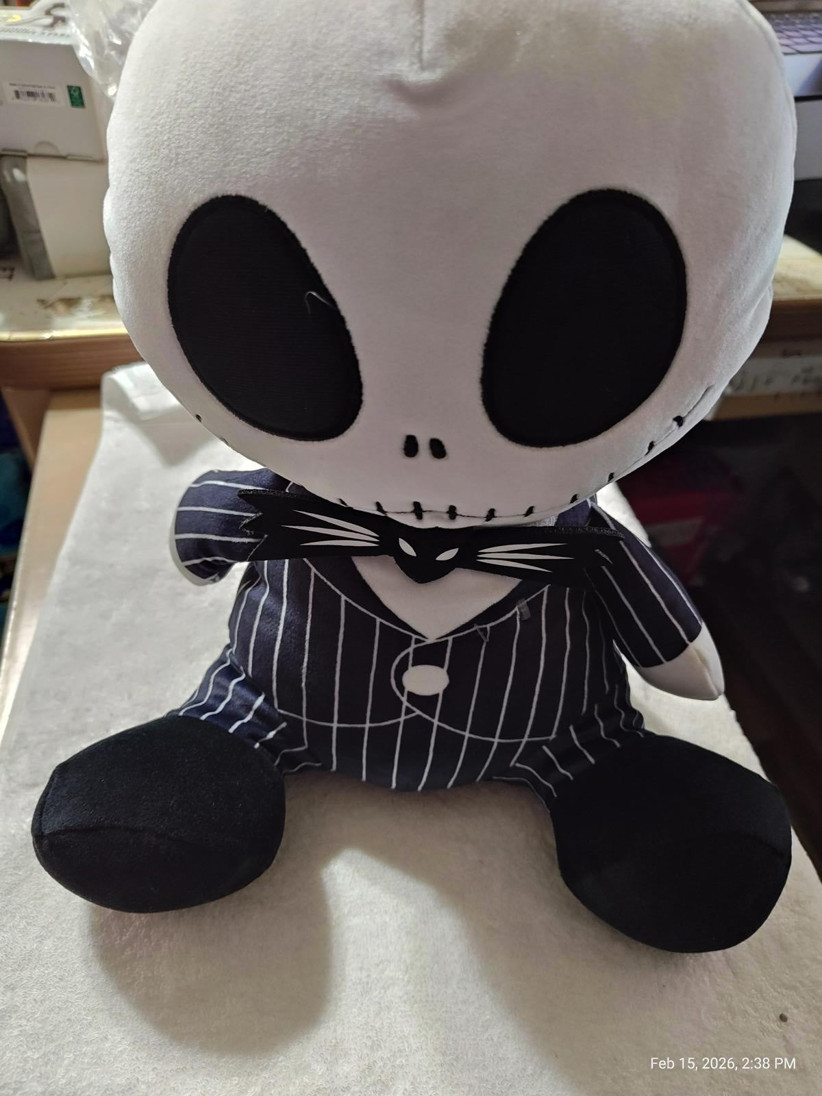 Jack Skellington plush toy in a pinstripe suit with large black eyes.