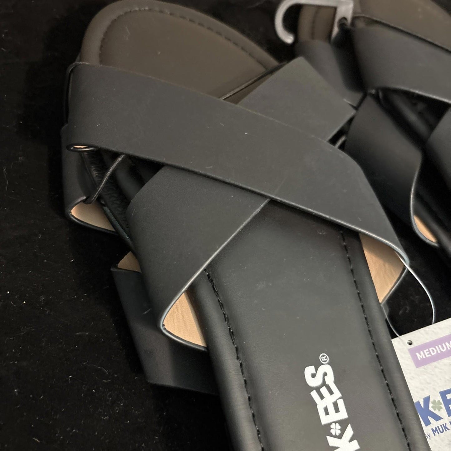 Keen sandals featuring a stylish black cross-strap design and comfortable footbed.