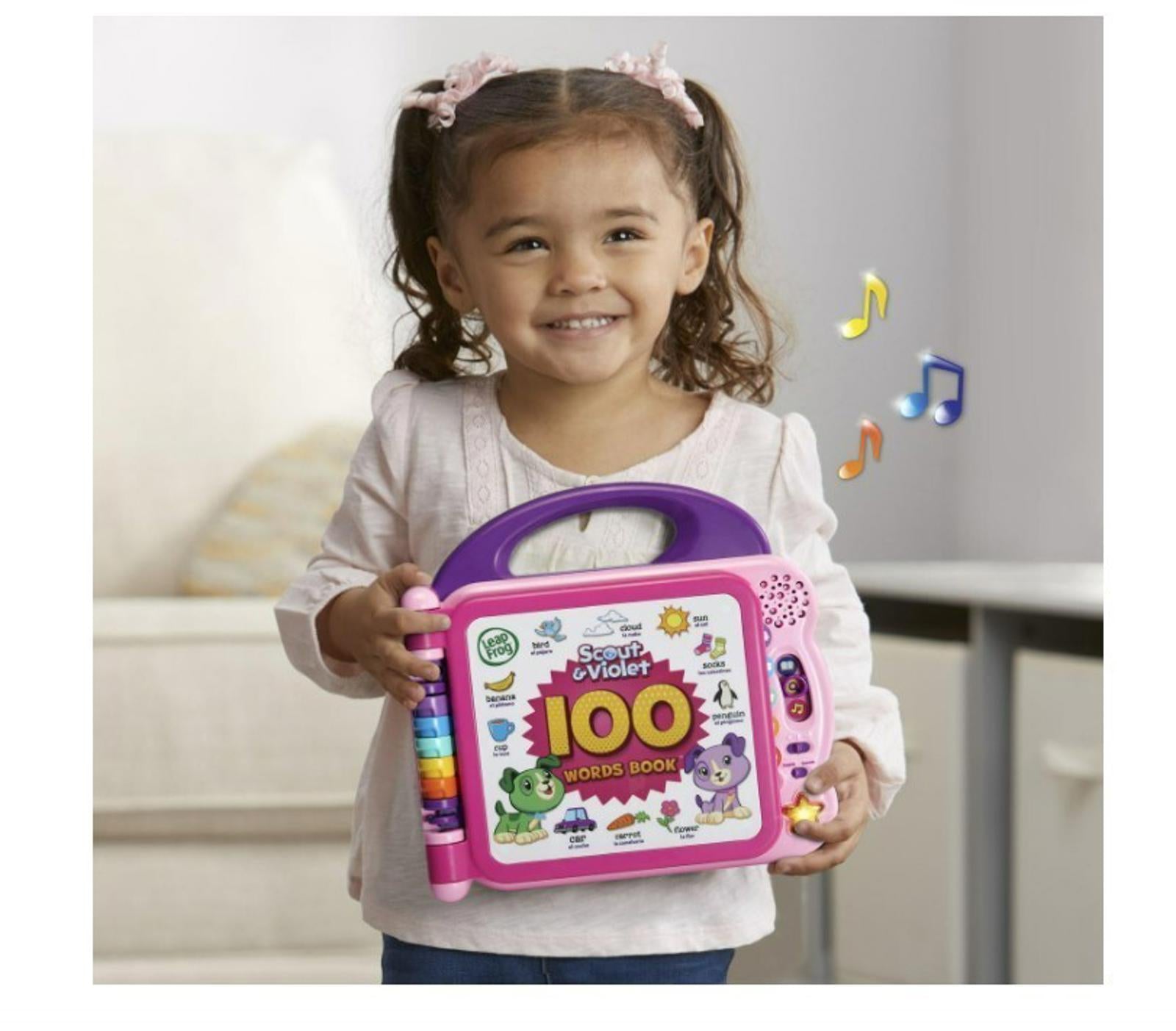Learning Resources 100 Words Book with colorful illustrations and sounds, held by a smiling child.