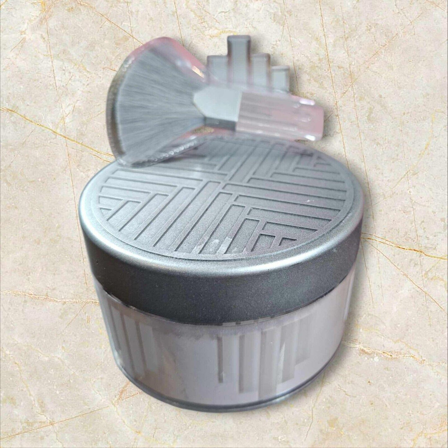 Makeup brush holder with a sleek design and textured lid for organized storage.