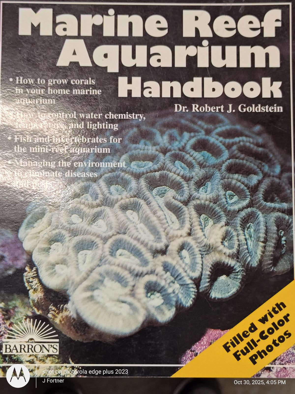 Marine Reef Aquarium Handbook by Dr. Robert J. Goldstein featuring coral growth tips and water chemistry.