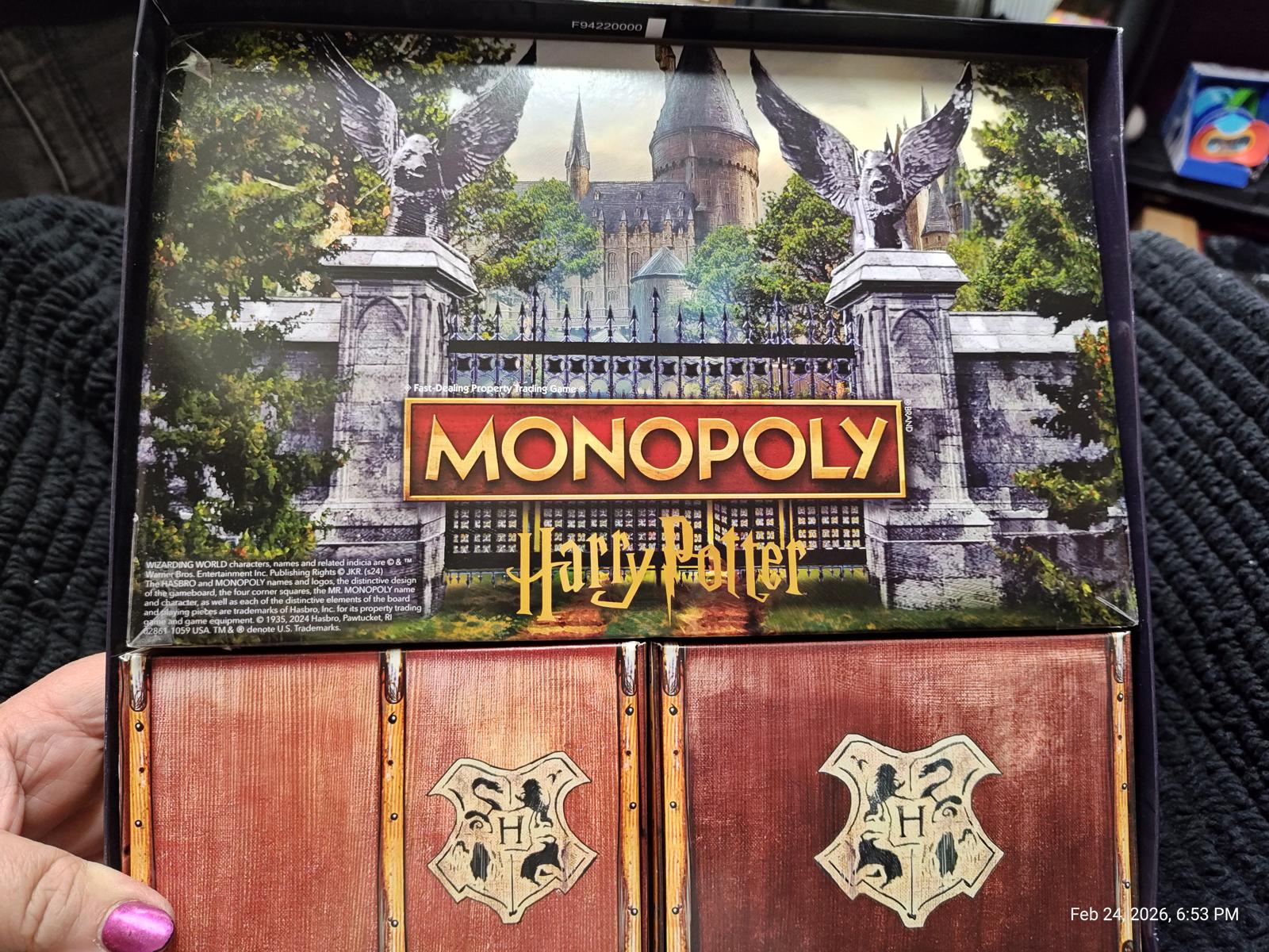 Monopoly Harry Potter game box featuring Hogwarts castle and game components.
