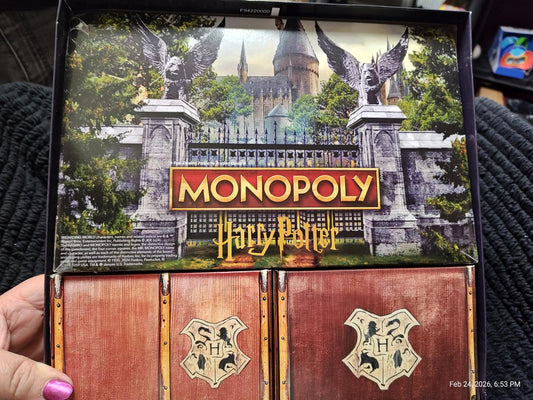 Monopoly Harry Potter game box featuring Hogwarts castle and game components.