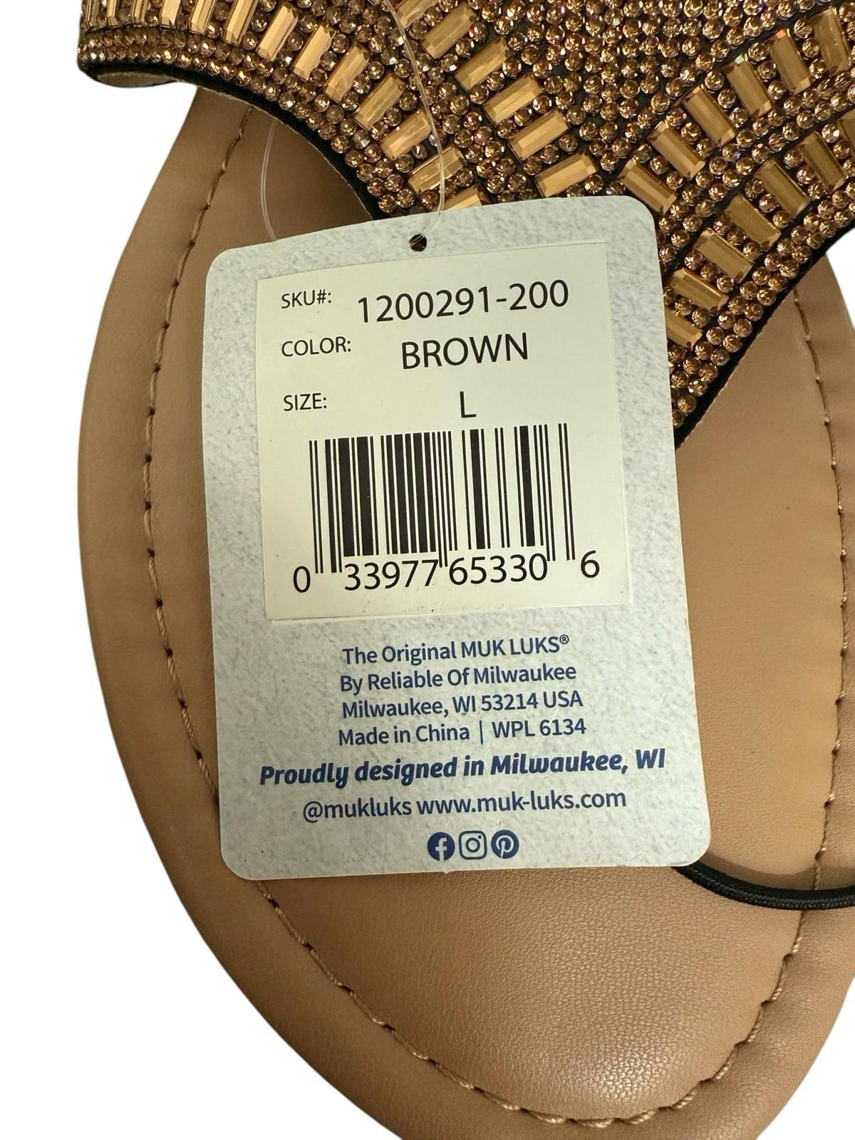 Muk Luks brown sandals with decorative embellishments and size tag.