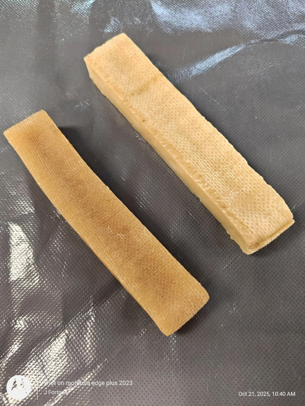 Natural Rubber Chew Toys for Dogs, two beige sticks on a textured surface.