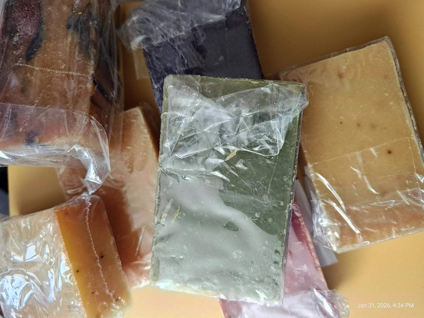 Natural Handmade Soap Bars in various colors and textures, wrapped in clear packaging.