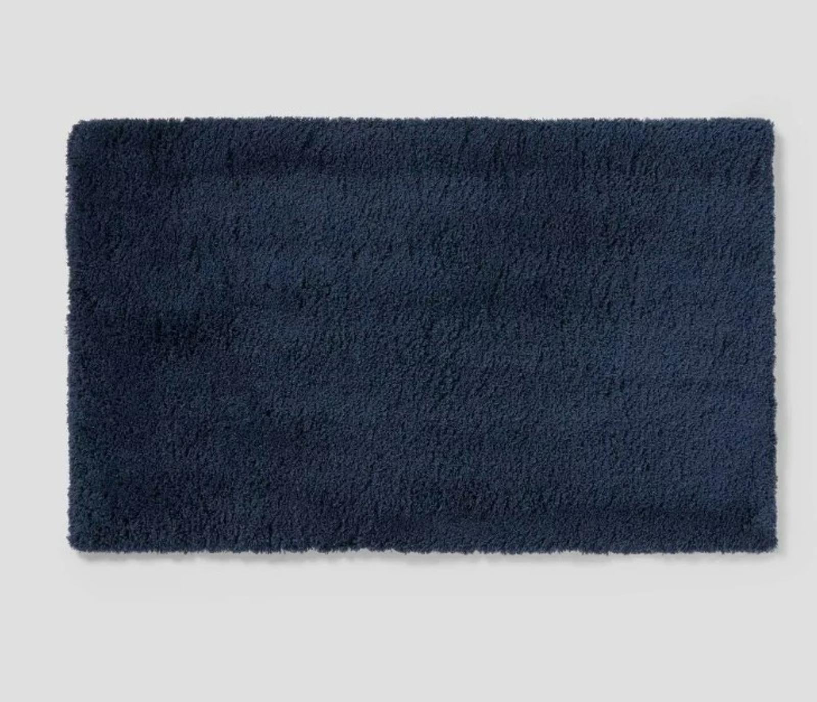 Navy plush bath mat with a soft texture for comfort and style.
