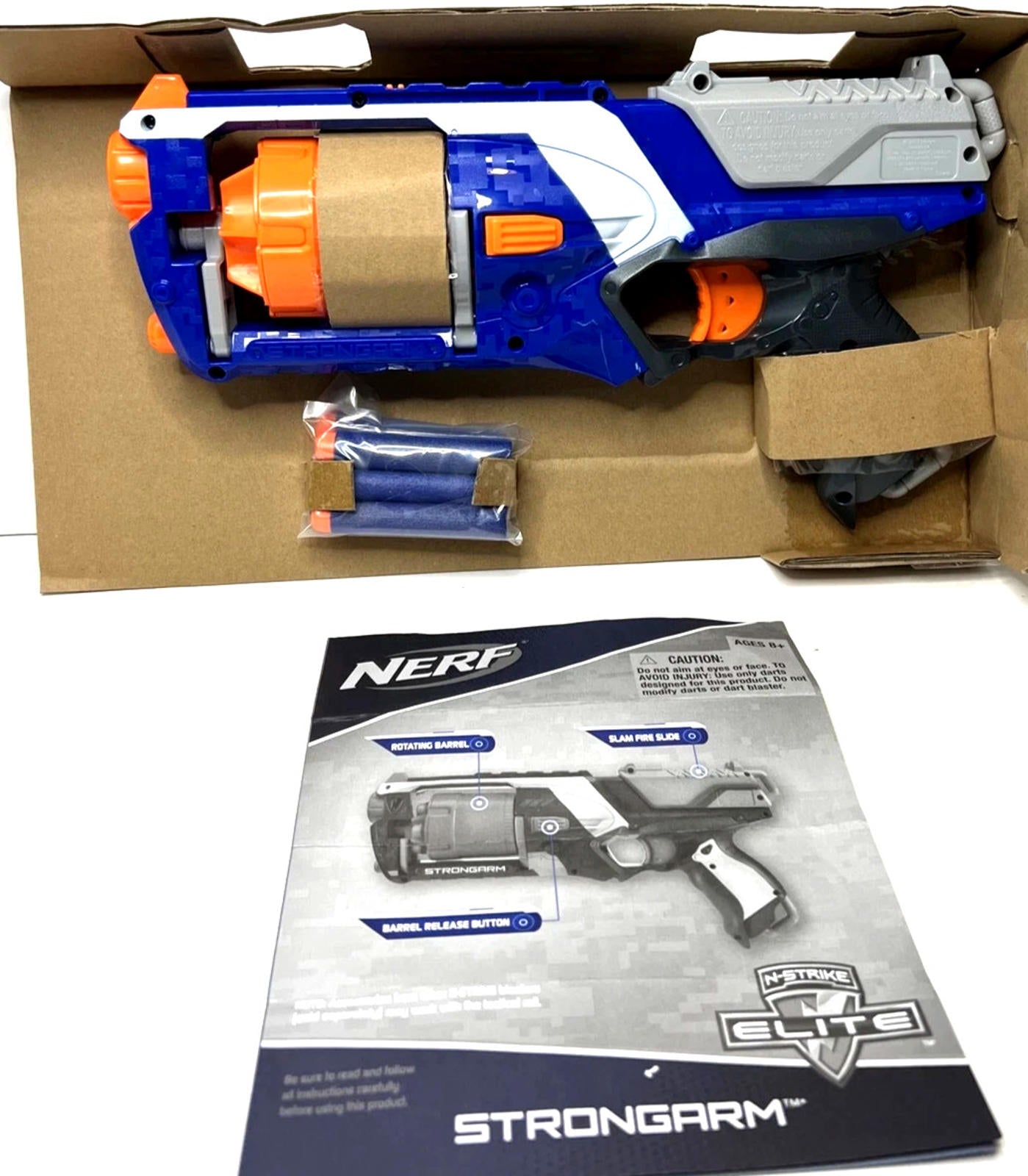 NERF Strongarm blaster in blue and orange with accessories in packaging.