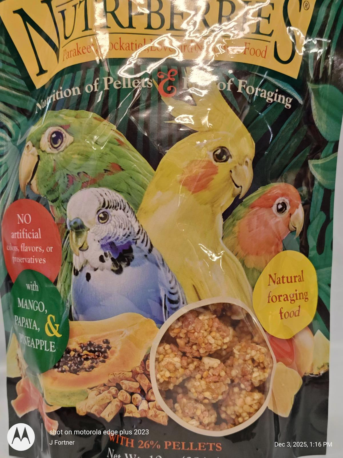 Nutriberries bird food with mango, papaya, and pineapple, featuring colorful parrots on the packaging.
