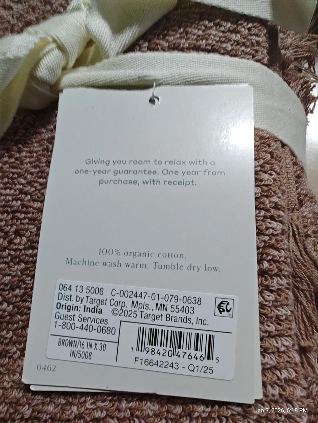 Organic Cotton Towel with a soft texture and care instructions tag.