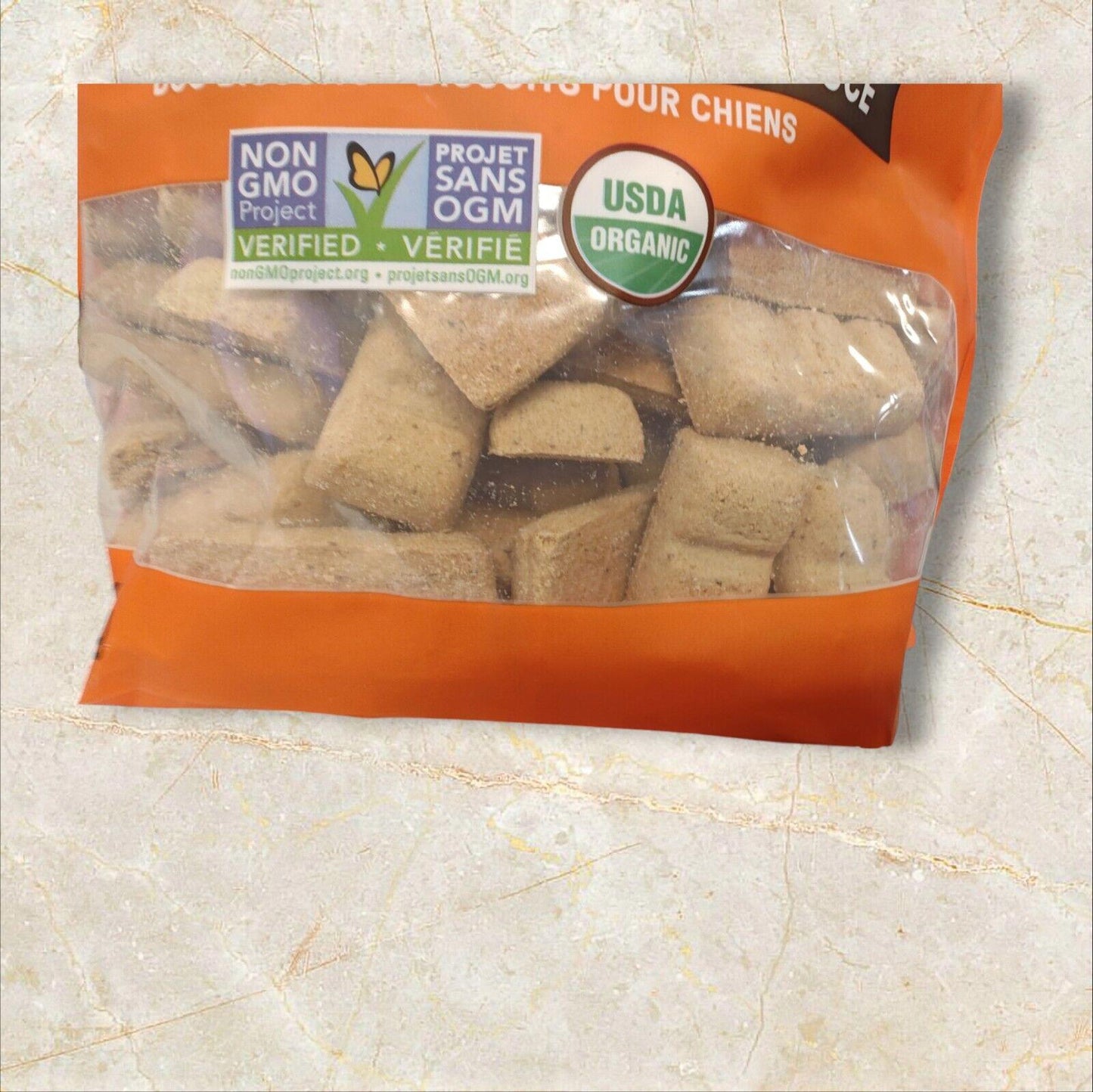 Organic dog treats in a clear bag with non-GMO certification and USDA organic label.