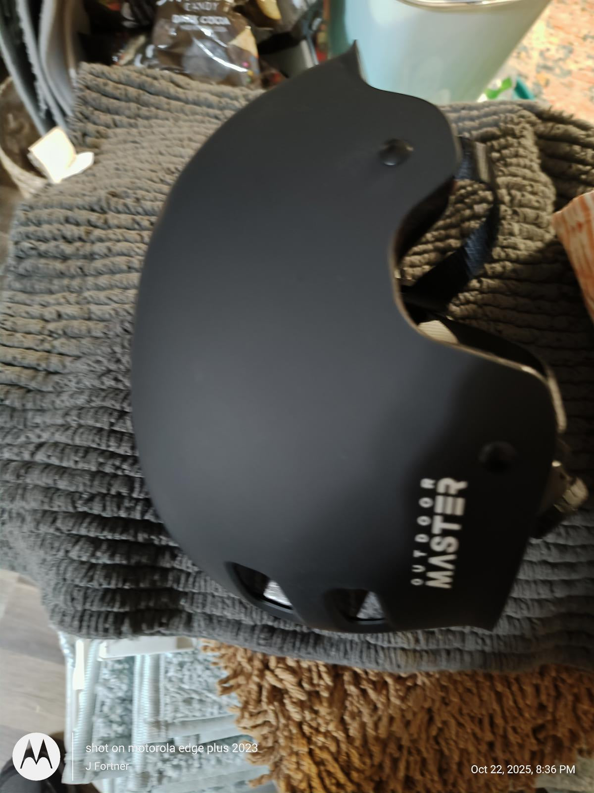 Outdoor Master helmet in matte black color, showcasing its sleek design and ventilation holes.