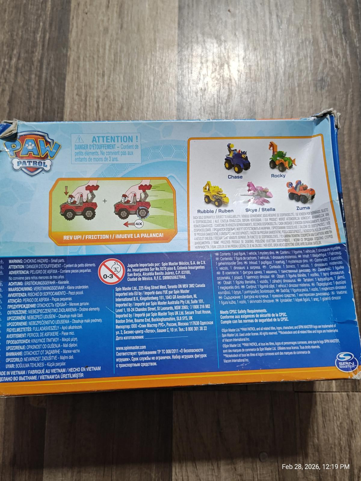 Paw Patrol toy box featuring colorful vehicles and characters, including a pink truck and a yellow tractor.