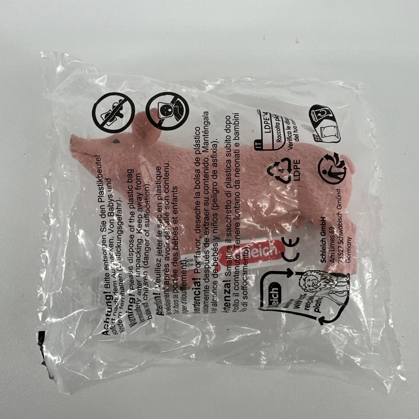 Pig toy figure in packaging, featuring a pink color and realistic details.