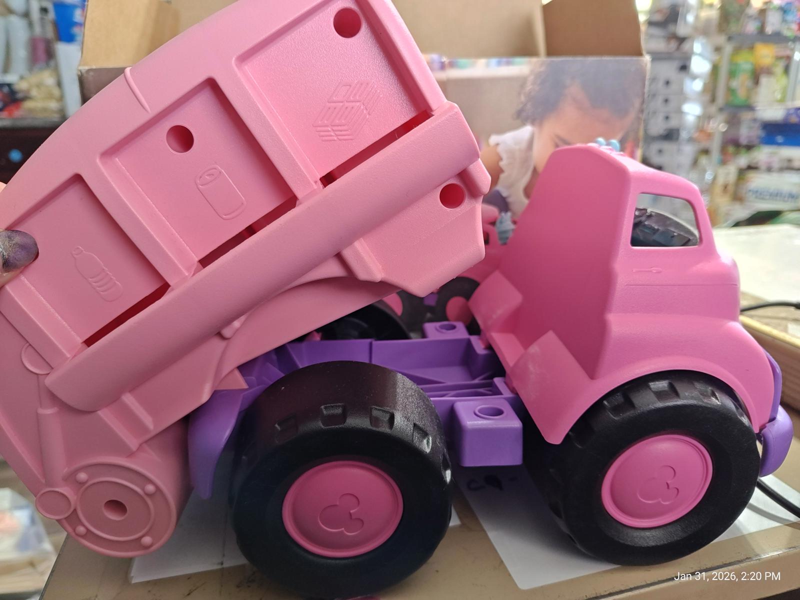 Pink Dump Truck toy with purple wheels and a tilting bed for imaginative play.