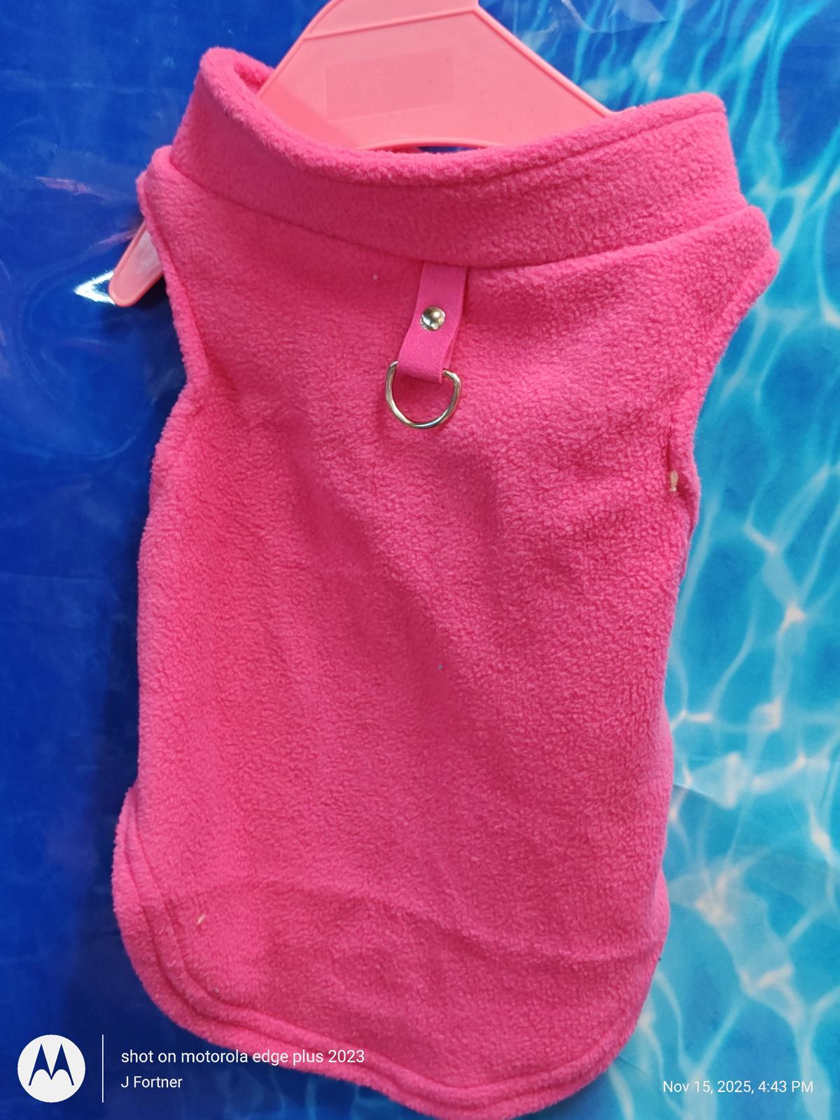 Pink fleece dog vest with a collar and D-ring for leash attachment.